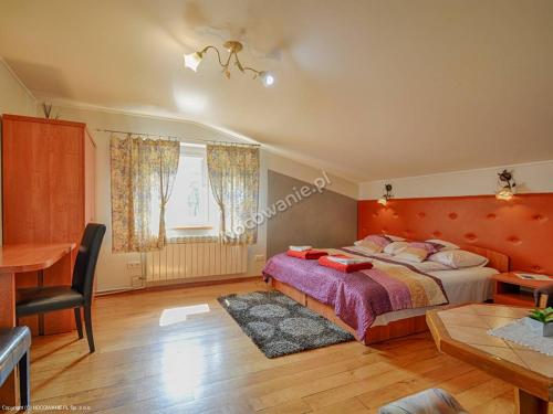 a bedroom with a bed and a table and a desk at Agroturystyka U Marty in Trzcinica
