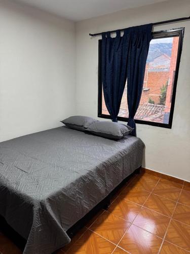 a bedroom with a bed and a window with a view at Casa del parque in Bello