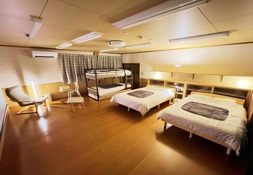 a hospital room with two beds and a chair at 鈴籠城 籠の間 - ダブル2台 二段ベッド1台 - 最大7名 in Nagahama
