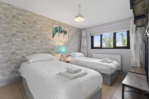 a bedroom with two beds and a brick wall at 2 Bed in Alkham oc-p34785 in Swingfield