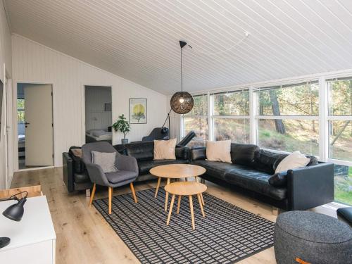 a living room with a black couch and a table at 5 star holiday home in Jerup in Jerup