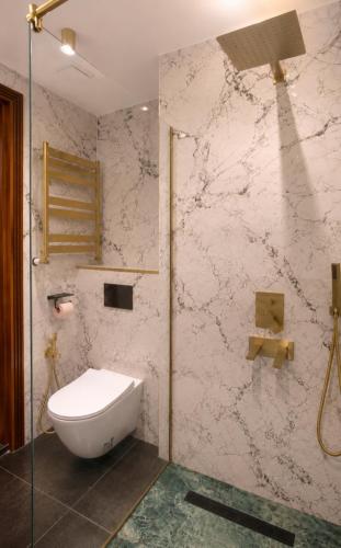 a bathroom with a toilet and a glass shower at Nautilus Apartment in Batumi