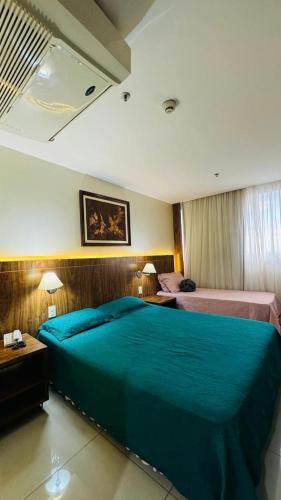 a bedroom with a large blue bed in a room at Quarto Mobiliado no Hotel Go Inn Taguatinga com Wi-Fi, Ar Condicionado e Estacionamento Grátis in Brasília