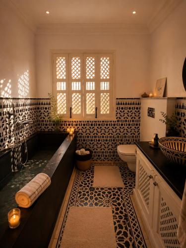 a large bathroom with a tub and a toilet at DAR COLIBRI - Maison de charme à Kélibia in Kelibia