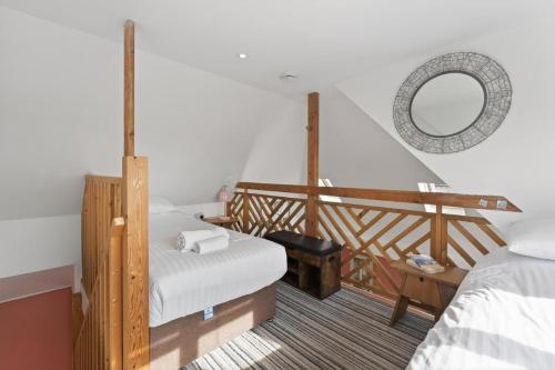 a room with two beds and a staircase with a mirror at 1 Bed in Alkham oc-s34788 in Swingfield