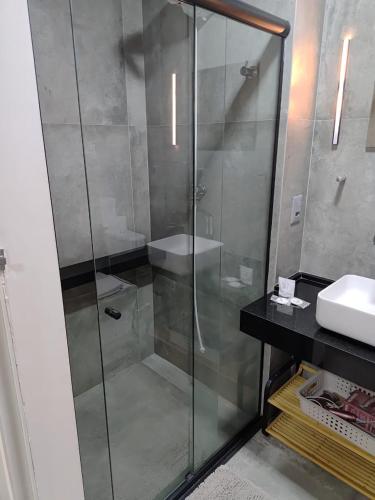 a bathroom with a glass shower and a sink at New Time 304 Maceió Alagoas in Maceió