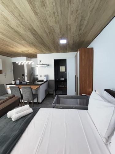 a living room with a large bed and a kitchen at New Time 304 Maceió Alagoas in Maceió