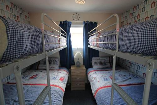 a bedroom with two bunk beds and a window at Sheppey Village Ollie in Leysdown-on-Sea