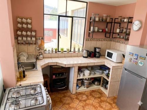 a small kitchen with a stove and a refrigerator at CAYESH Guest House in Huaraz
