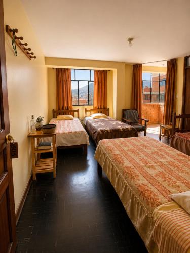 a hotel room with two beds and a window at CAYESH Guest House in Huaraz