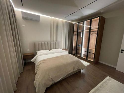 a bedroom with a large bed and a large window at L olive Villa in Zogaji