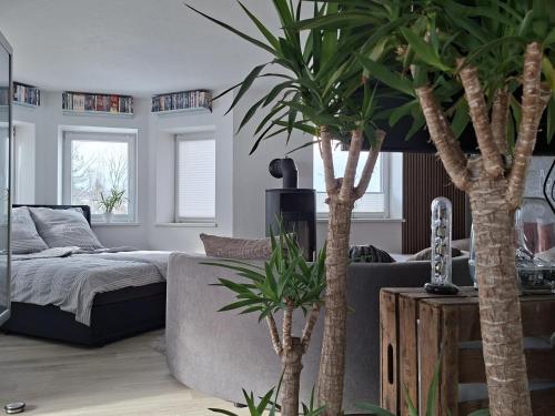 ein Wohnzimmer mit einem Bett und zwei Palmen in der Unterkunft Franziska in Schwoich