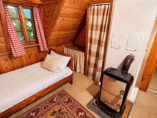 a room with a bed and a stove in a cabin at Almhütte Seebergalm in Seewiesen