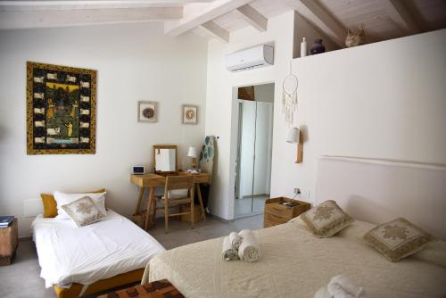 a bedroom with two beds and a table with a desk at Exclusive Villa Aurea with private pool in Cugnana