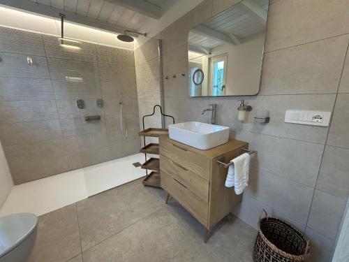 a bathroom with a sink and a shower and a toilet at Exclusive Villa Aurea with private pool in Cugnana
