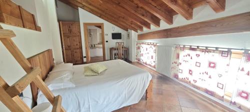 a bedroom with a white bed and a large window at Affittacamere I Picchi in Gressan