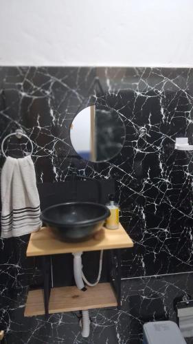 a black bathroom with a sink and a mirror at Vivendas Raízes do forte in Praia do Forte