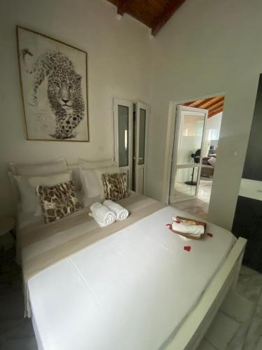 a large white bed in a room with a mirror at VillaBadlou "Lodge Ti-Kaco Vanille" in Trois-Rivières