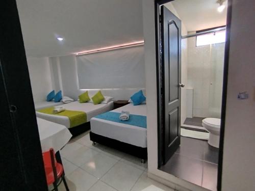 a hotel room with two beds and a toilet at HOTEL ANAPOIMA PLAZA IN in Anapoima
