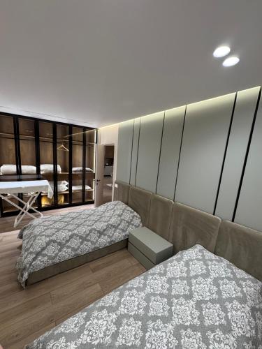 a bedroom with two beds and a couch at Modern Lake Apartment Tirana - Quiet Stay near Liqeni i Thatë in Tirana
