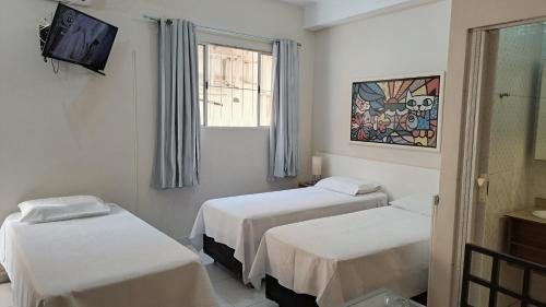 a hospital room with two beds and a tv at 10 Studios in São Paulo