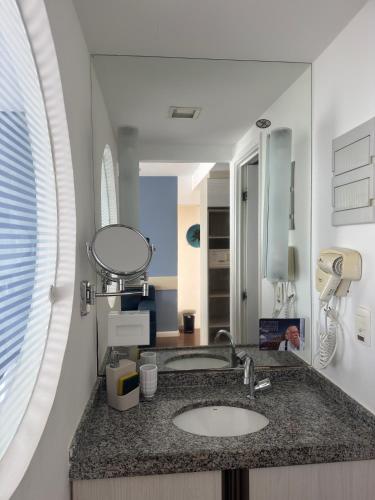 a bathroom with a sink and a mirror at Flat Recife - Boa Viagem in Recife