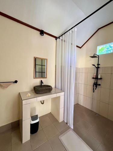 a bathroom with a sink and a shower at Di rumah Vima homestay in Pemuteran