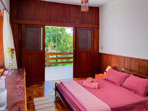 a bedroom with a pink bed with a pink blanket at Casa Smile in Teresópolis