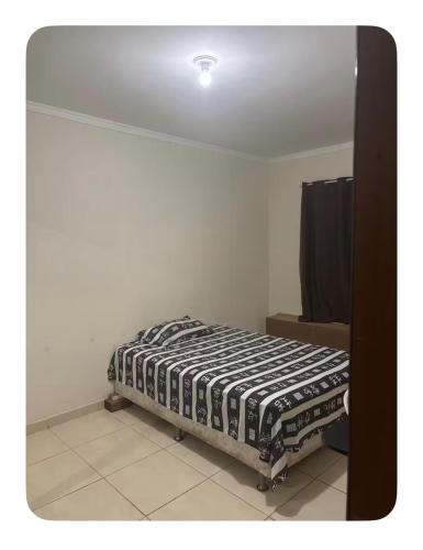 a bedroom with a bed in the corner of a room at Raquel in Londrina