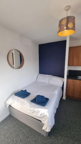 a bedroom with a bed with two blue pillows on it at Self-Contained Studio Private Bathroom Sleeps 2 in Nottingham