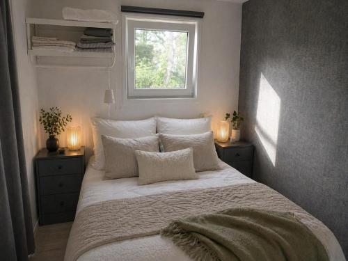 a bedroom with a large white bed with a window at Vechtdal Chalet de Berk in Rheezerveen