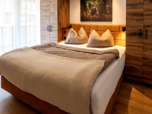 a bedroom with a large bed with white sheets and pillows at Spacious suite for 8 guests with a private sauna in Rauris