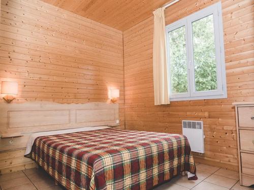 a bedroom with a bed in a wooden room at Cozy Cottage Retreat for Two in Moutiers-sous-Chantemerle