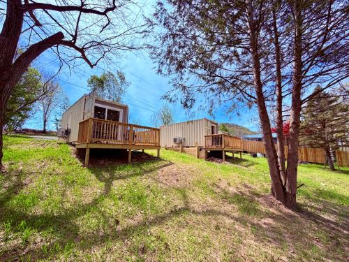 a group of modular homes on a hill with trees at Romantic Riverfront Retreat in Sugar Run