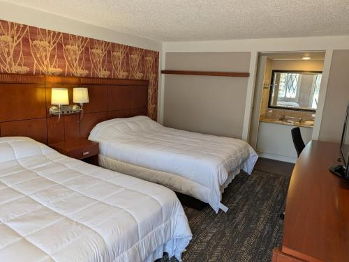 a hotel room with two beds and a window at Exceed Inn Indianapolis Airport South in Indianapolis