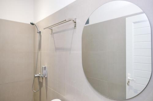 a bathroom with a mirror and a shower at Urbanview Hotel Subali Purwokerto in Purwokerto