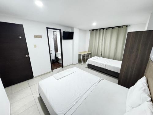 a hotel room with two beds and a television at Torre 2 Bucare in Yopal