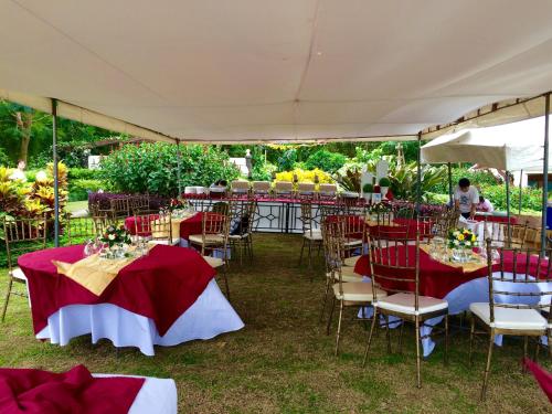 a group of tables and chairs under a tent at Ataalaya Farmhouse in Batangas City