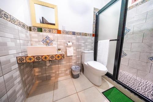 a bathroom with a toilet and a sink at Los Faroles Hotel & Spa in Antigua Guatemala