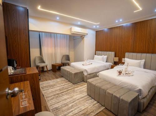 a hotel room with two beds and a living room at Tuya pyramids INN in Cairo