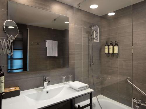 a bathroom with a tub and a sink and a shower at Novotel Santiago Vitacura in Santiago