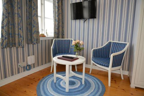 a room with two chairs and a table and a tv at Hotel Ærø in Svendborg