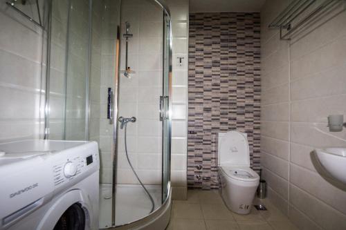 a bathroom with a shower and a toilet and a sink at My Batumi Apartments in Batumi