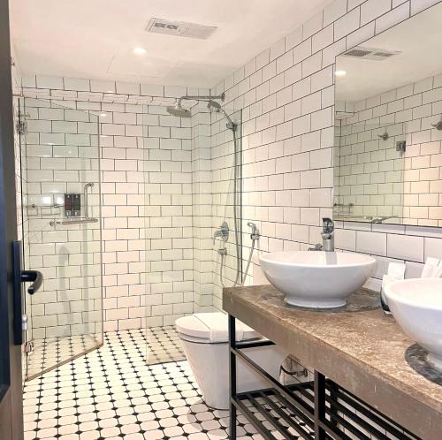 a bathroom with two sinks and a toilet at JonkeRED Heritage Hotel in Malacca