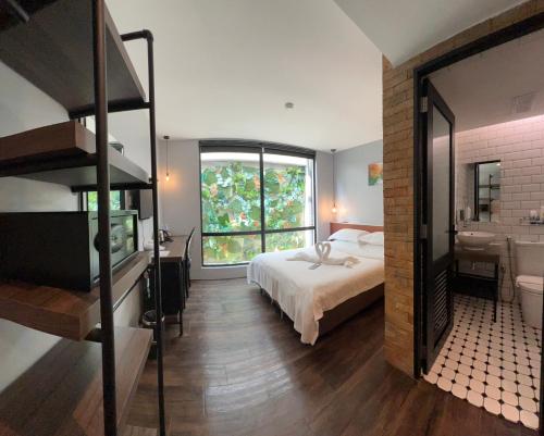 a bedroom with a bed and a large window at JonkeRED Heritage Hotel in Malacca