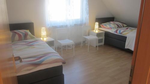 1 Schlafzimmer mit 2 Betten, einem Tisch und Stühlen in der Unterkunft Komfort Apartment 1 DG Jürgen Kunzi in Filderstadt