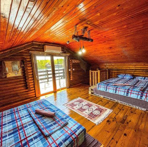 a bedroom with two beds in a log cabin at Sara Riverside Cottage in Ulcinj