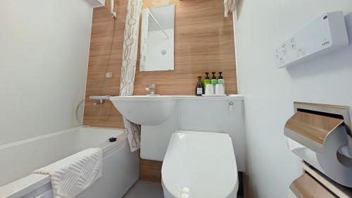a bathroom with a toilet and a sink and a tub at Ueno Touganeya Hotel in Tokyo