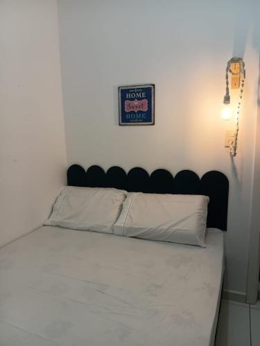 a bed in a room with a sign on the wall at Apto aconchegante próximo à UFS in São Cristóvão