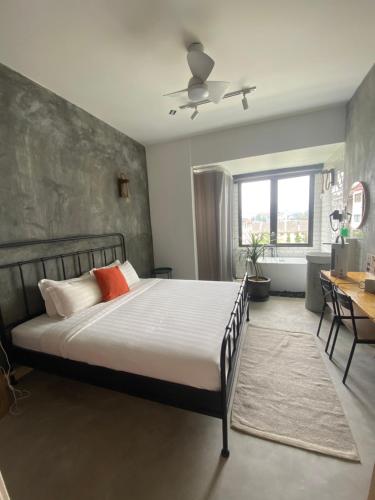 a bedroom with a large bed and a desk at Silvan Garden Retreat in Tanah Rata